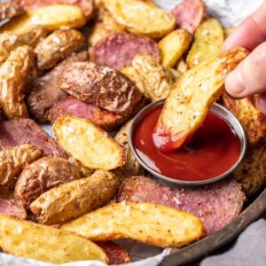 Air fryer fingerling potato dipped in ketchup.