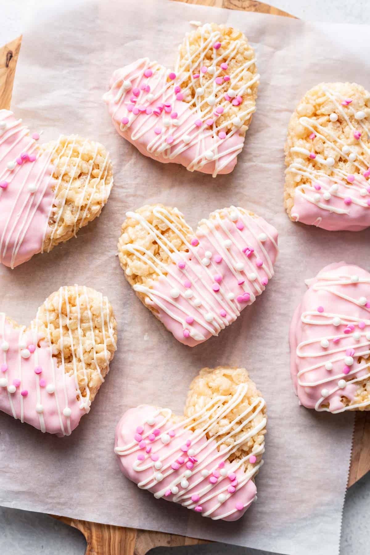 Heart shaped rice krispie treats decorated with white and pink sprinkles.