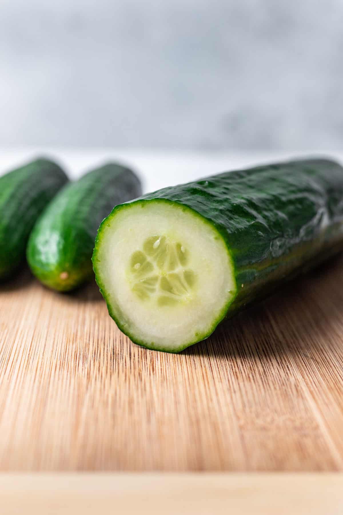 A cucumber cut on a cutting board to show the interior seeds.