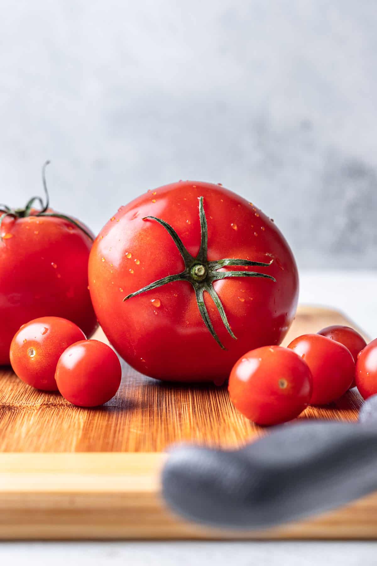 Tomatoes on a wood cutting board.