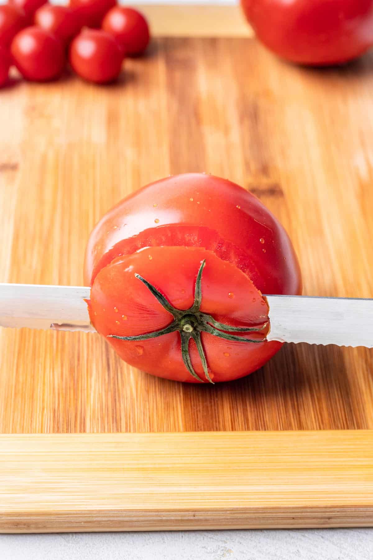 Cutting the top off a tomato.