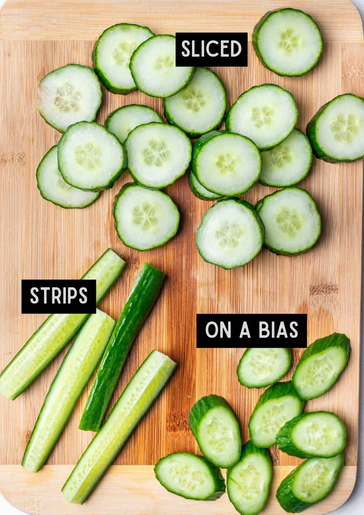 Different cuts of cucumbers on a cutting board.