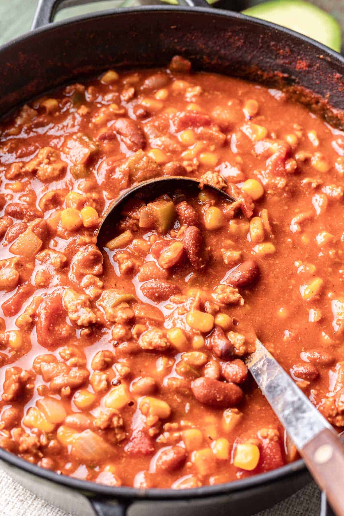 Chili in a dutch oven with a ladle.