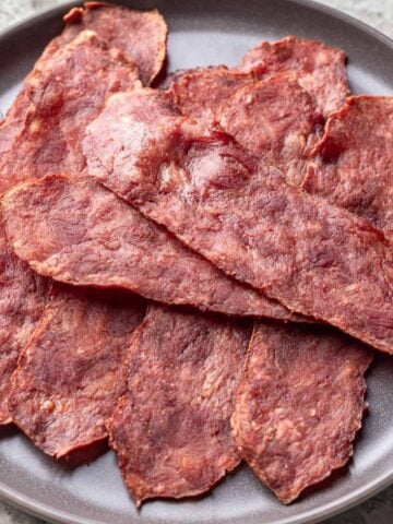 Turkey bacon piled on a gray plate.