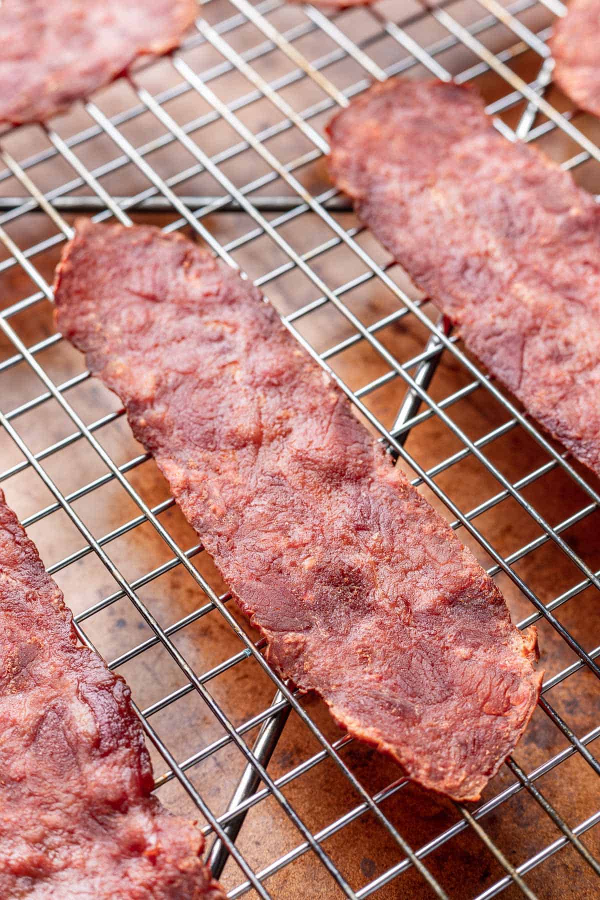 Cooked turkey bacon on a rack on top of a sheet pan.