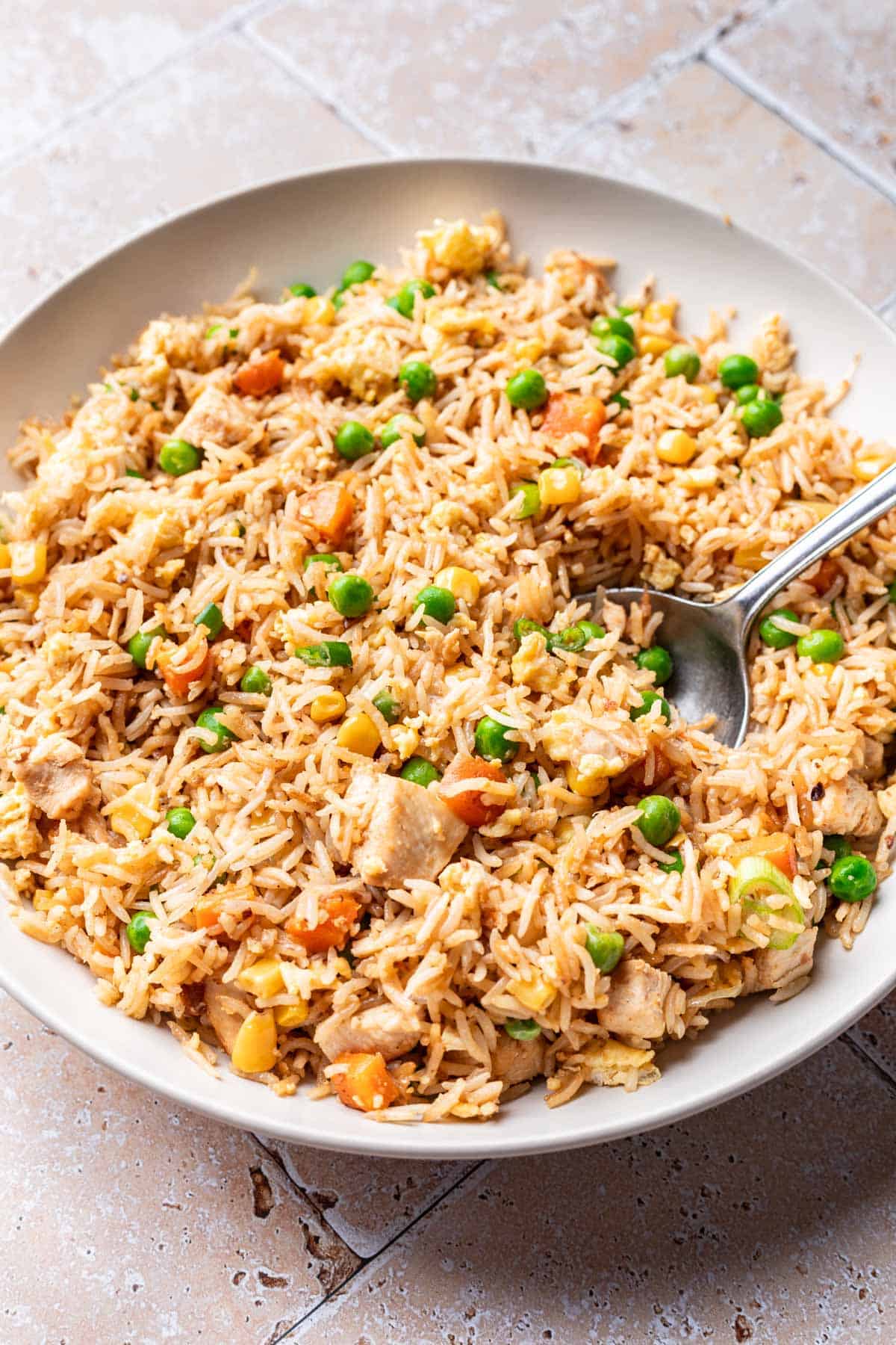 Instant pot chicken fried rice in a serving bowl with a spoon.