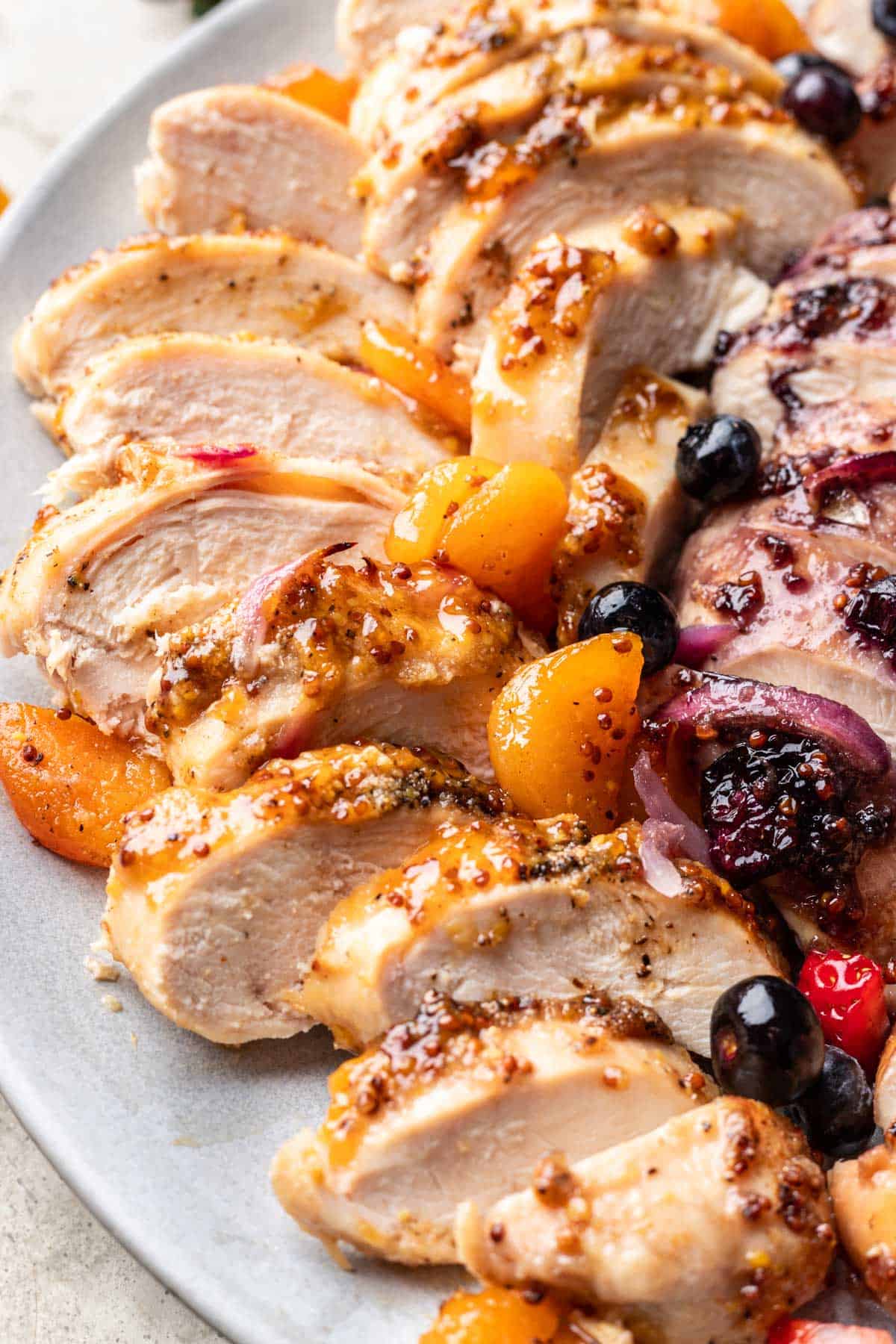 Sliced apricot jelly chicken on a serving plate.