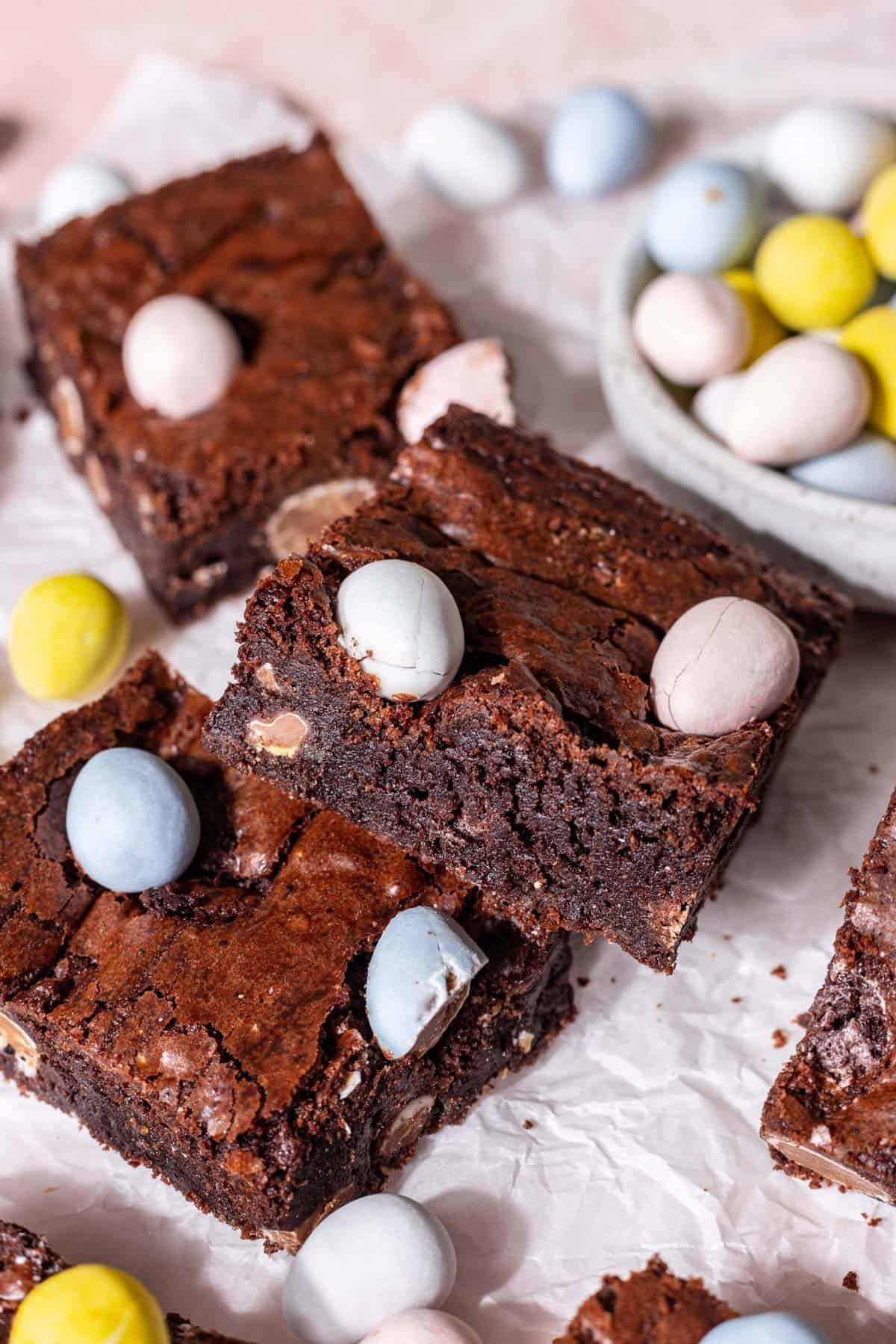 Mini easter egg brownies stacked on top of each other to show the fudgy center.