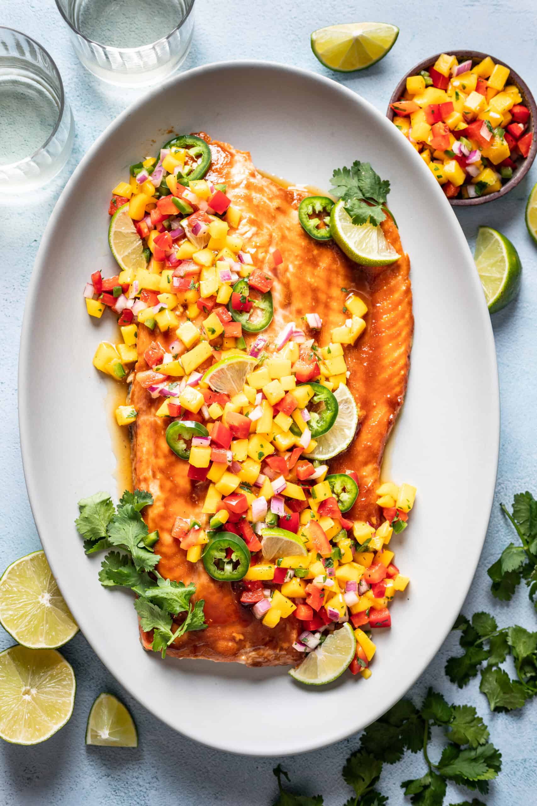 Salmon with mango salsa on a serving platter.