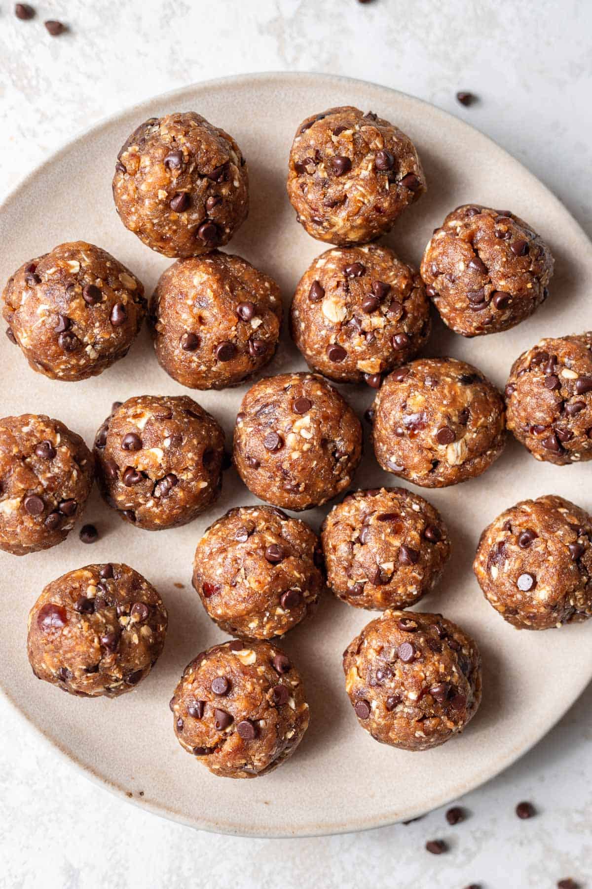 Peanut butter bliss balls with chocolate chips on a serving plate.