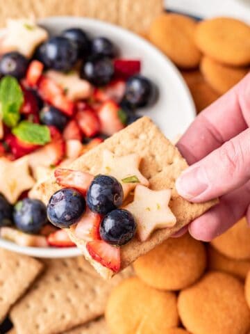 Graham cracker with red white and blue fruit salsa on top.