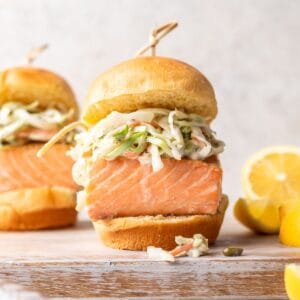 A salmon slider on a brioche bun with coleslaw.