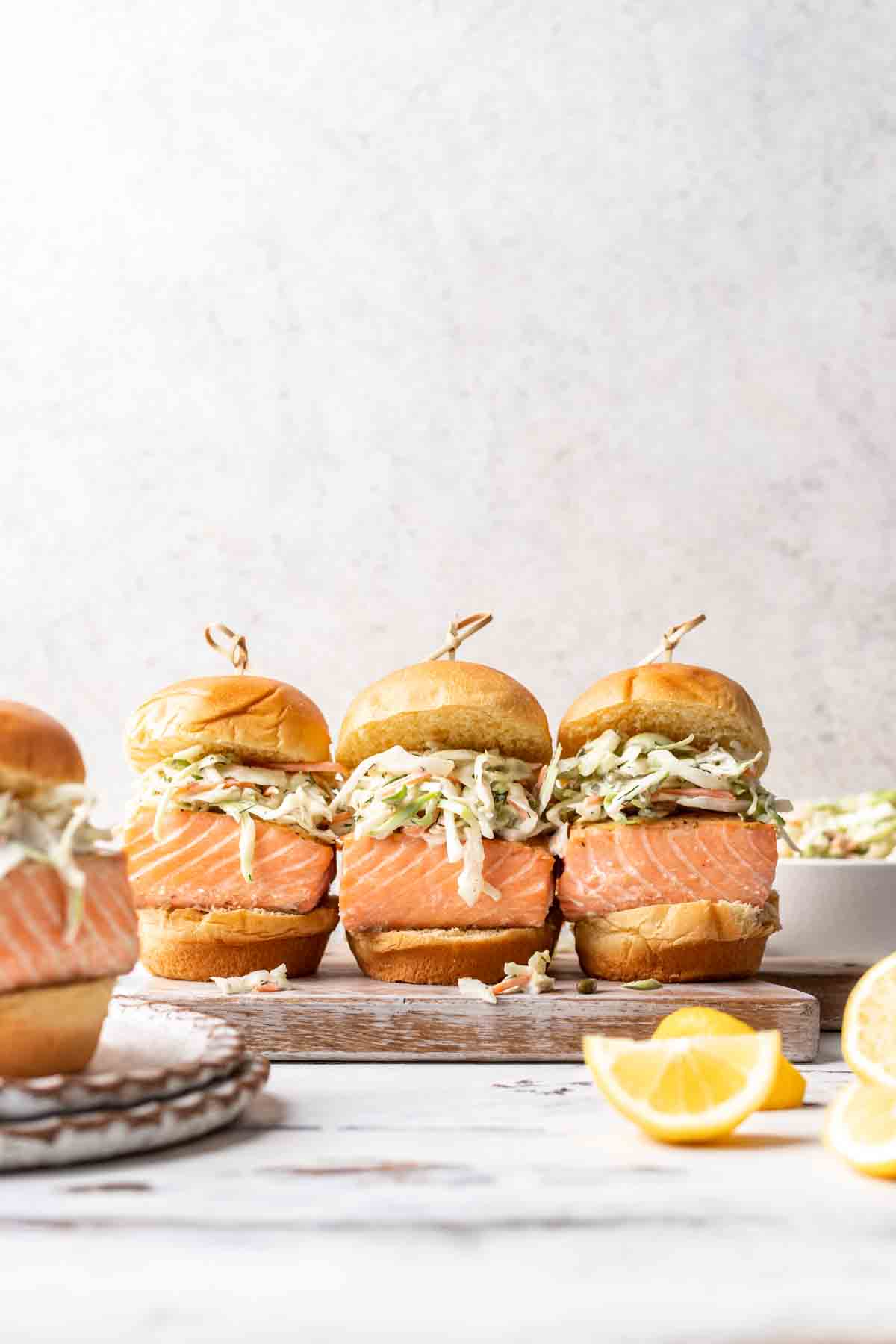 3 salmon sliders on a serving tray.