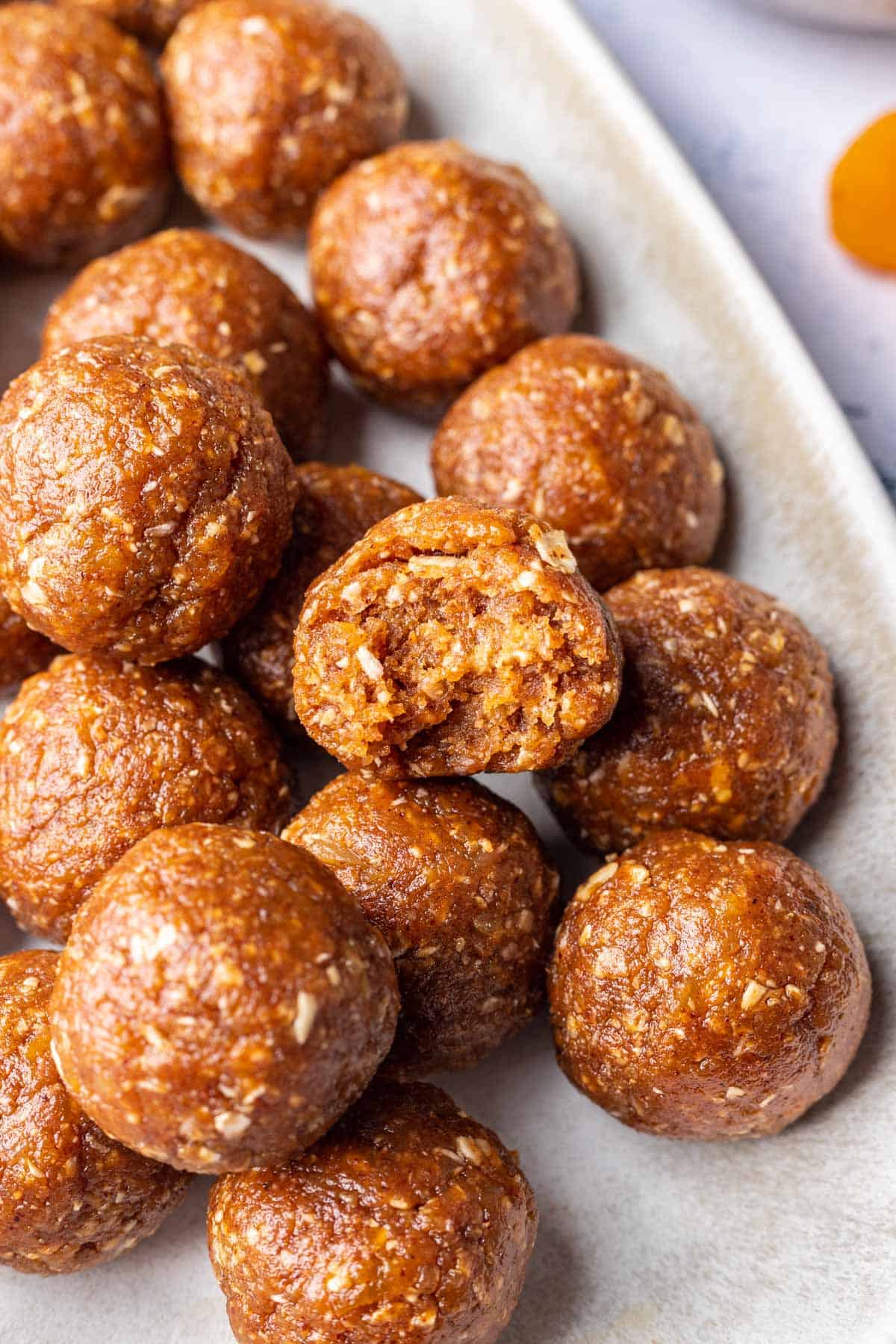 Apricot bliss balls stacked on a platter.