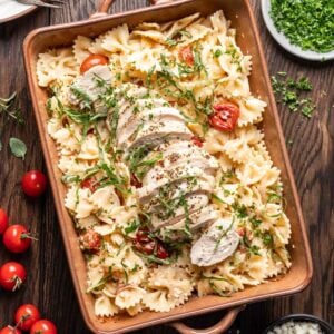 Chicken feta pasta in a baking dish with fresh basil on top.