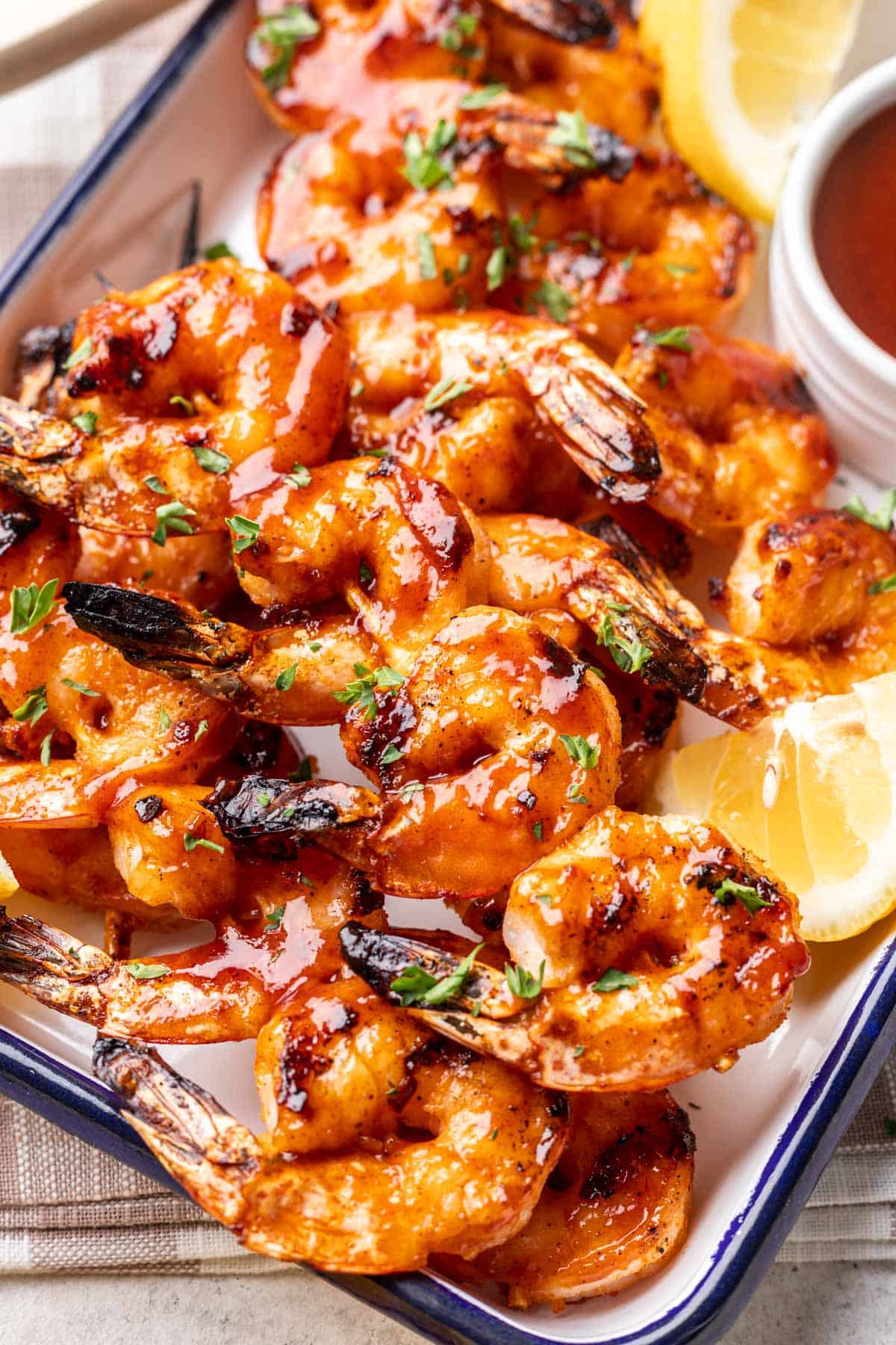 Grilled shrimp with BBQ sauce on a serving platter.