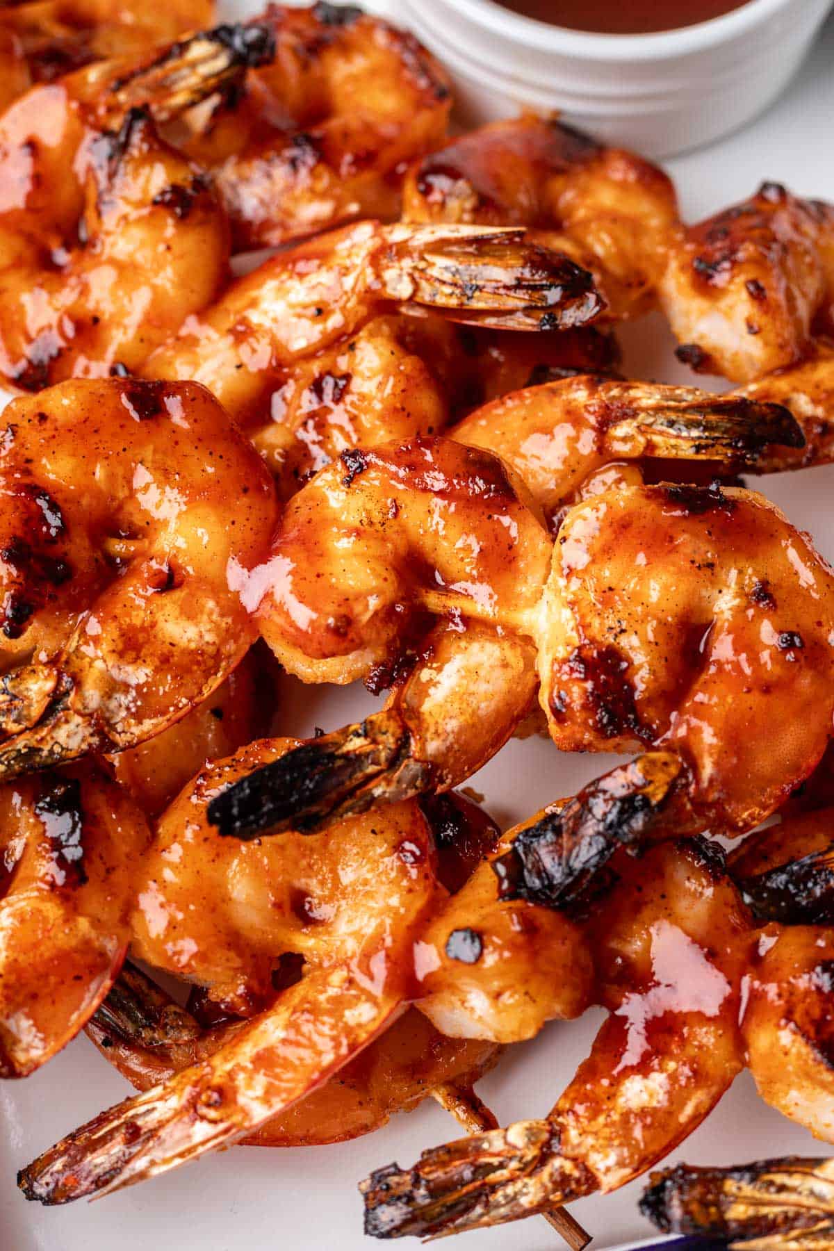 Shrimp coated in BBQ sauce on a skewer.