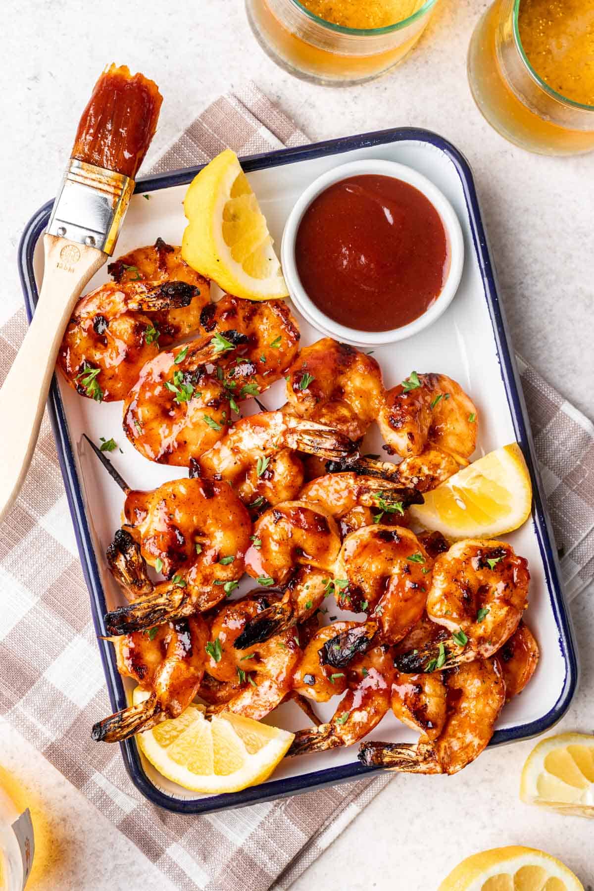 Grilled shrimp, brushed with BBQ sauce, on a serving platter.