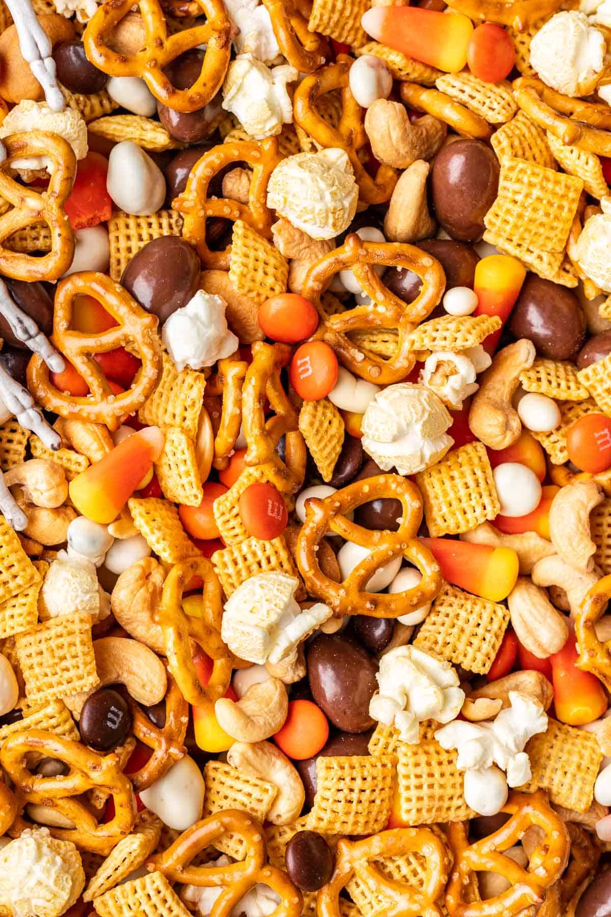Pretzels, chex cereal, kettle corn, m&ms, yogurt raisins, and chocolate almonds mixed together to create Halloween trail mix.