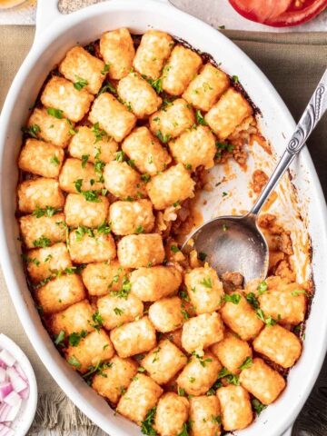 Cheeseburger tater tot casserole in an oval baking dish.