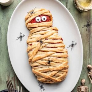 Halloween mummy meatloaf with candy eyes on a serving platter.