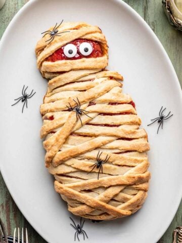 Halloween mummy meatloaf with candy eyes on a serving platter.