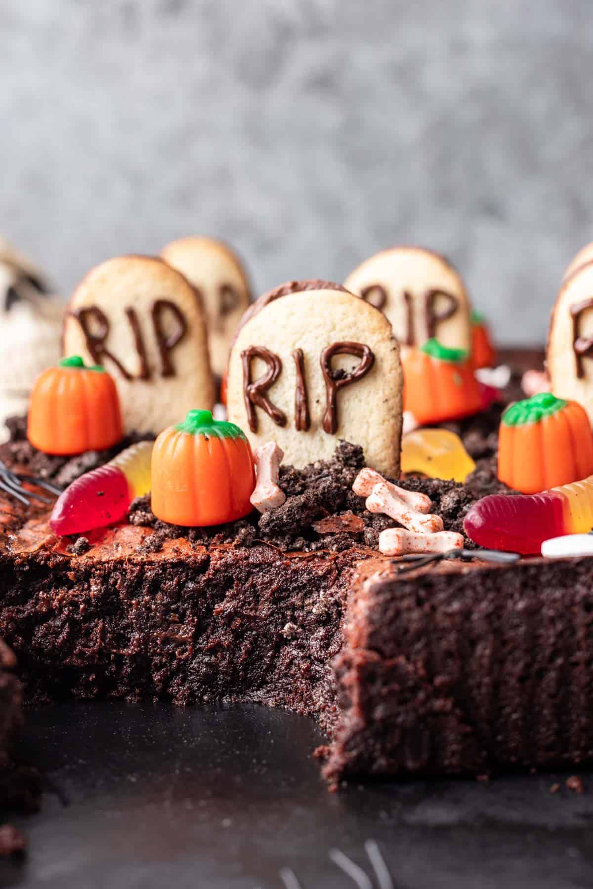 Graveyard brownies with oval cookies that look like tombstones and other Halloween candy decorations.