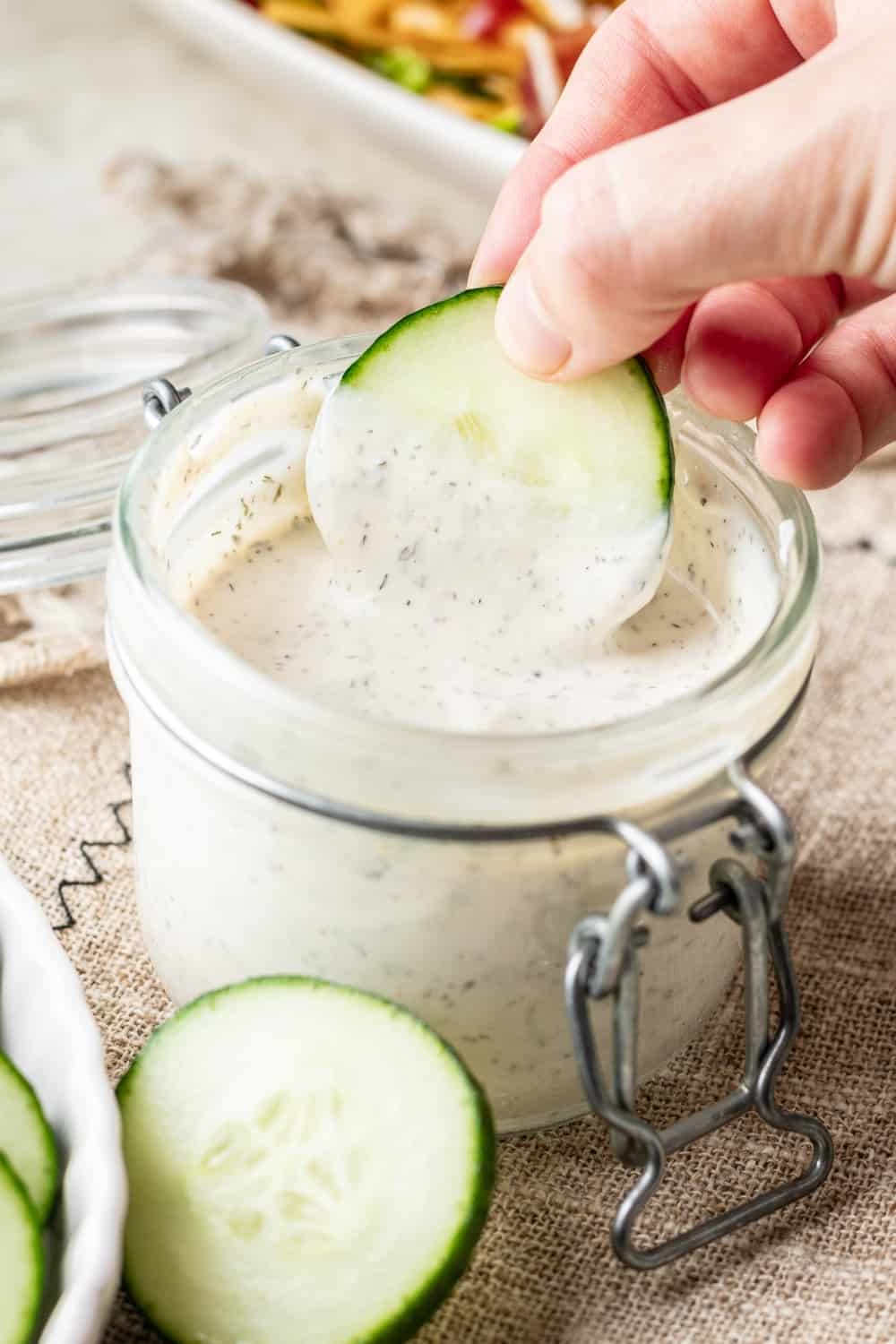 A cucumber dipped in greek yogurt ranch dressing.