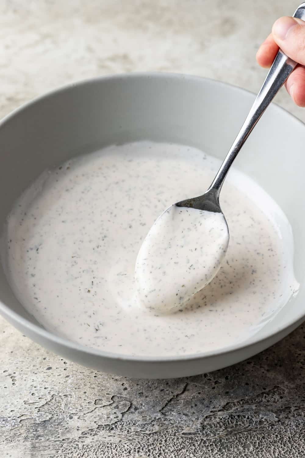 Greek yogurt ranch dressing in a bowl with a spoon.
