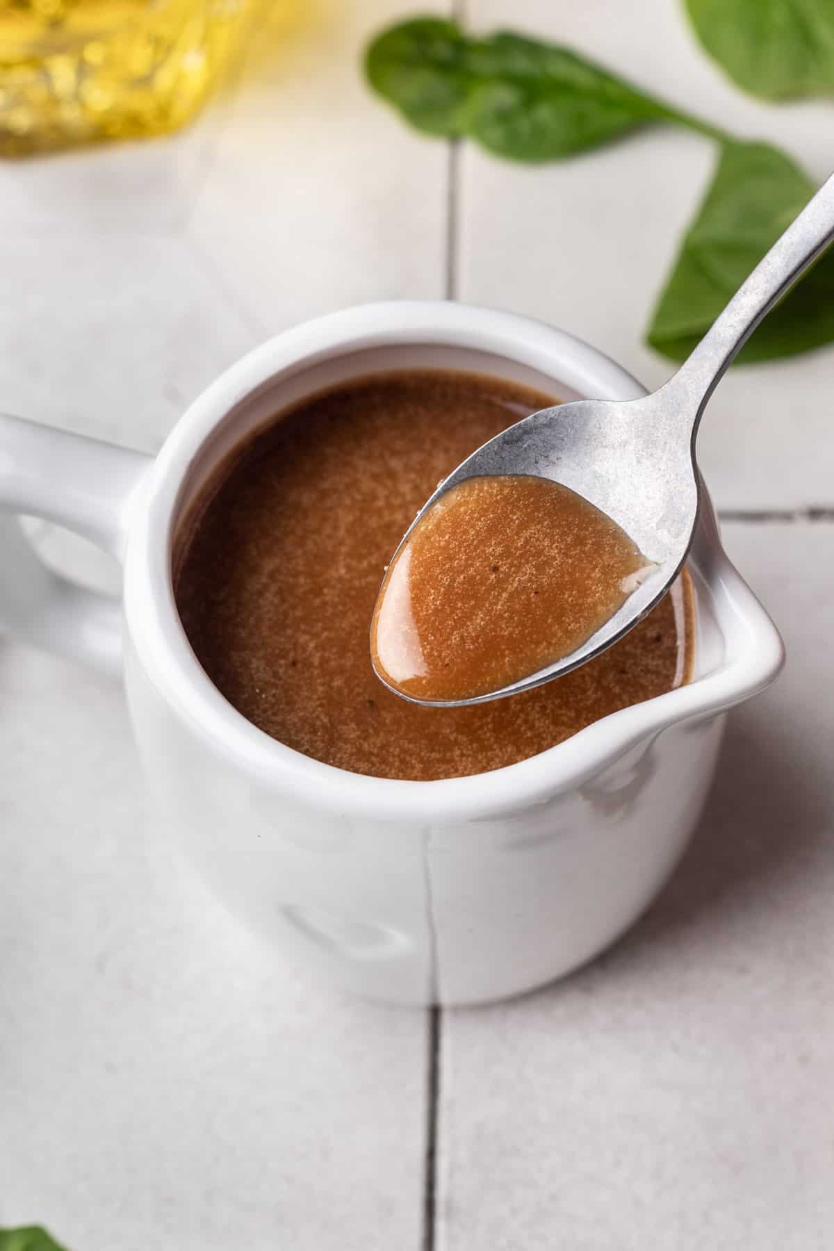 Thick maple balsamic dressing shown on a spoon.