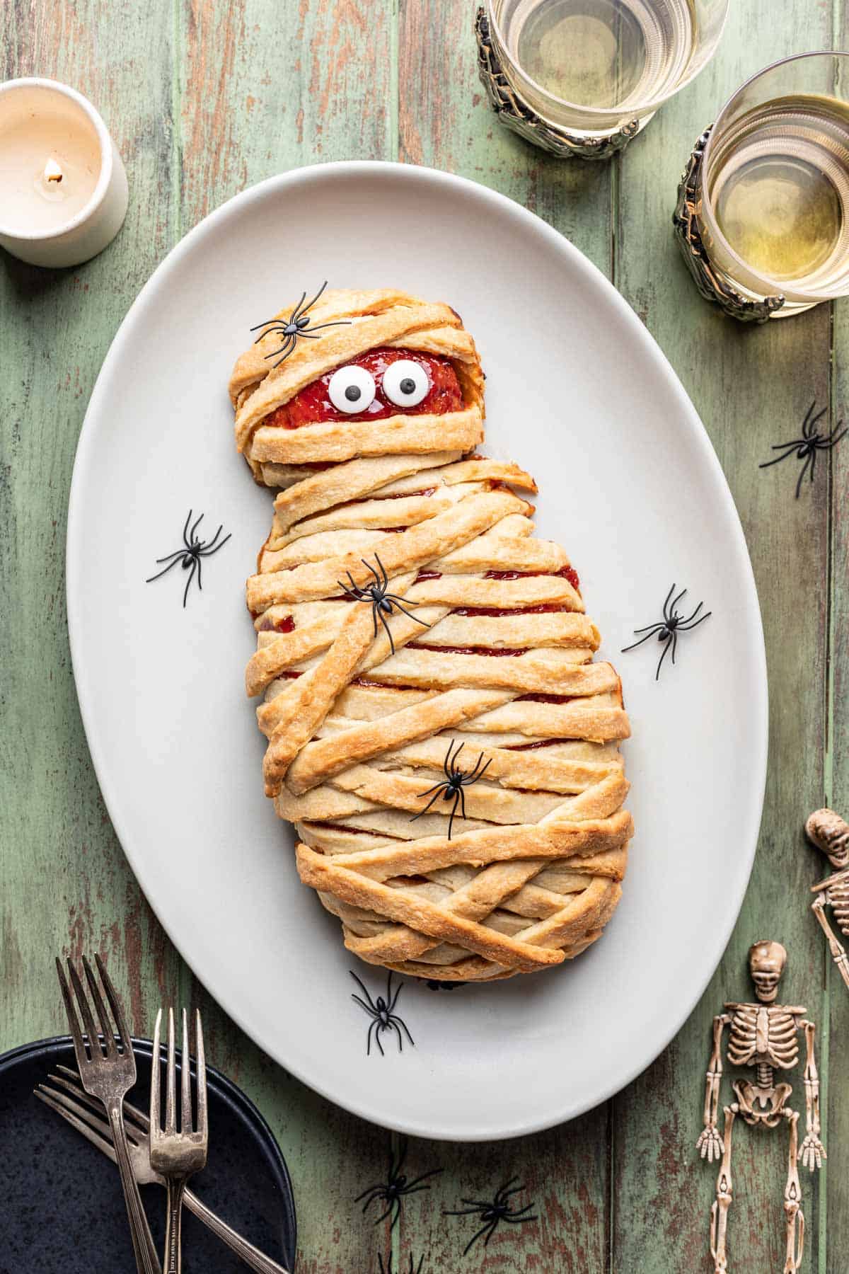 Mummy meatloaf with candy eyes on a serving platter.