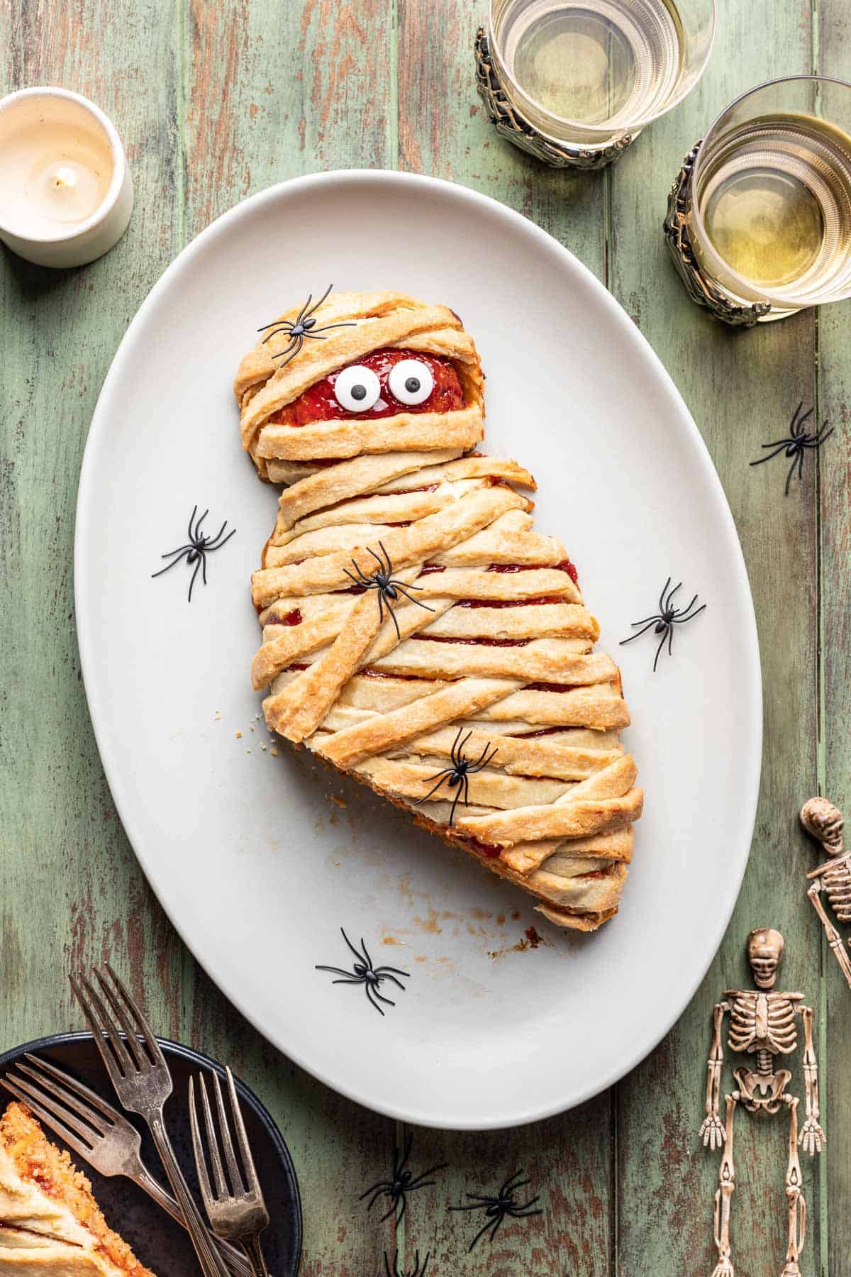 Sliced mummy meatloaf with golden brown dough draped on top.