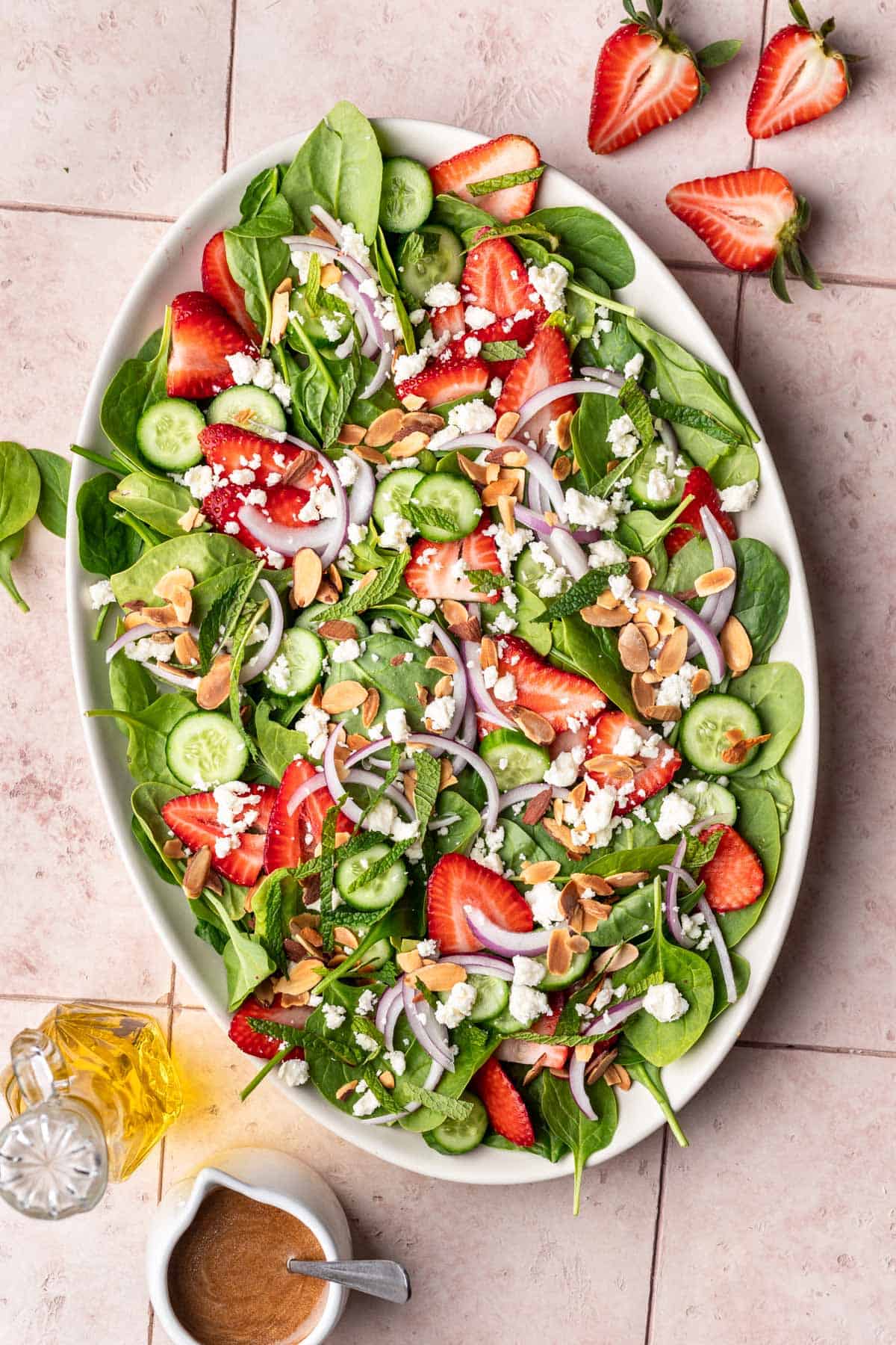 Strawberry Cucumber salad with toppings, dressing, and fresh strawberries.