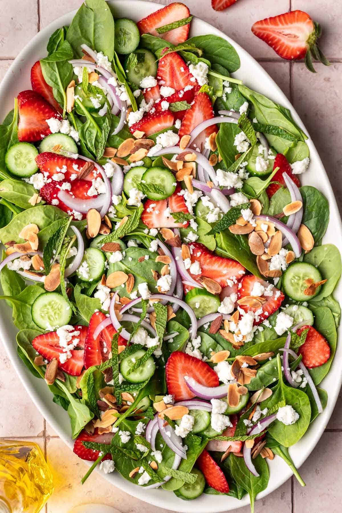 Strawberry cucumber salad with feta, red onions, strawberries, cucumbers, and greens.