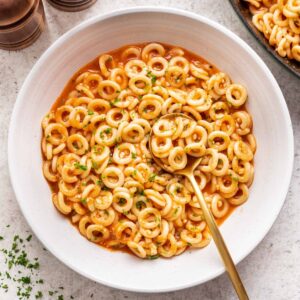 Spaghettios in a bowl with a spoon.