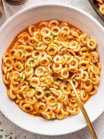 Spaghettios in a bowl with a spoon.