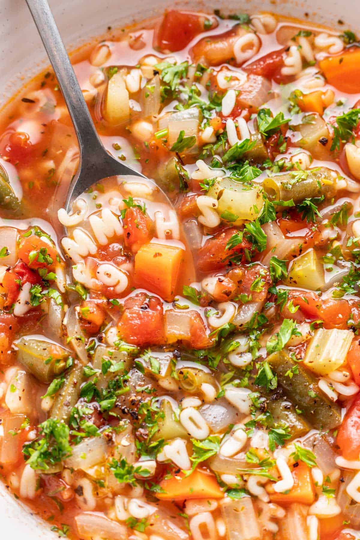 Alphabet soup loaded with ABC pasta and veggies in a bowl.
