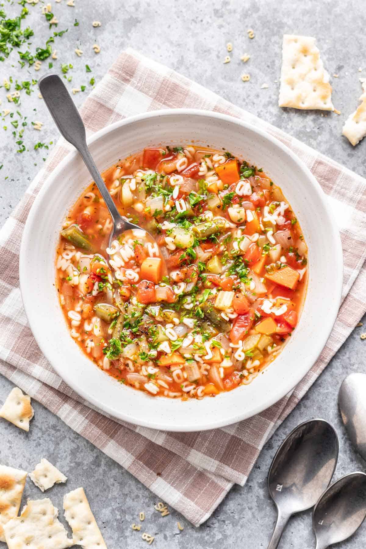 Alphabet soup in a bowl with a spoon.