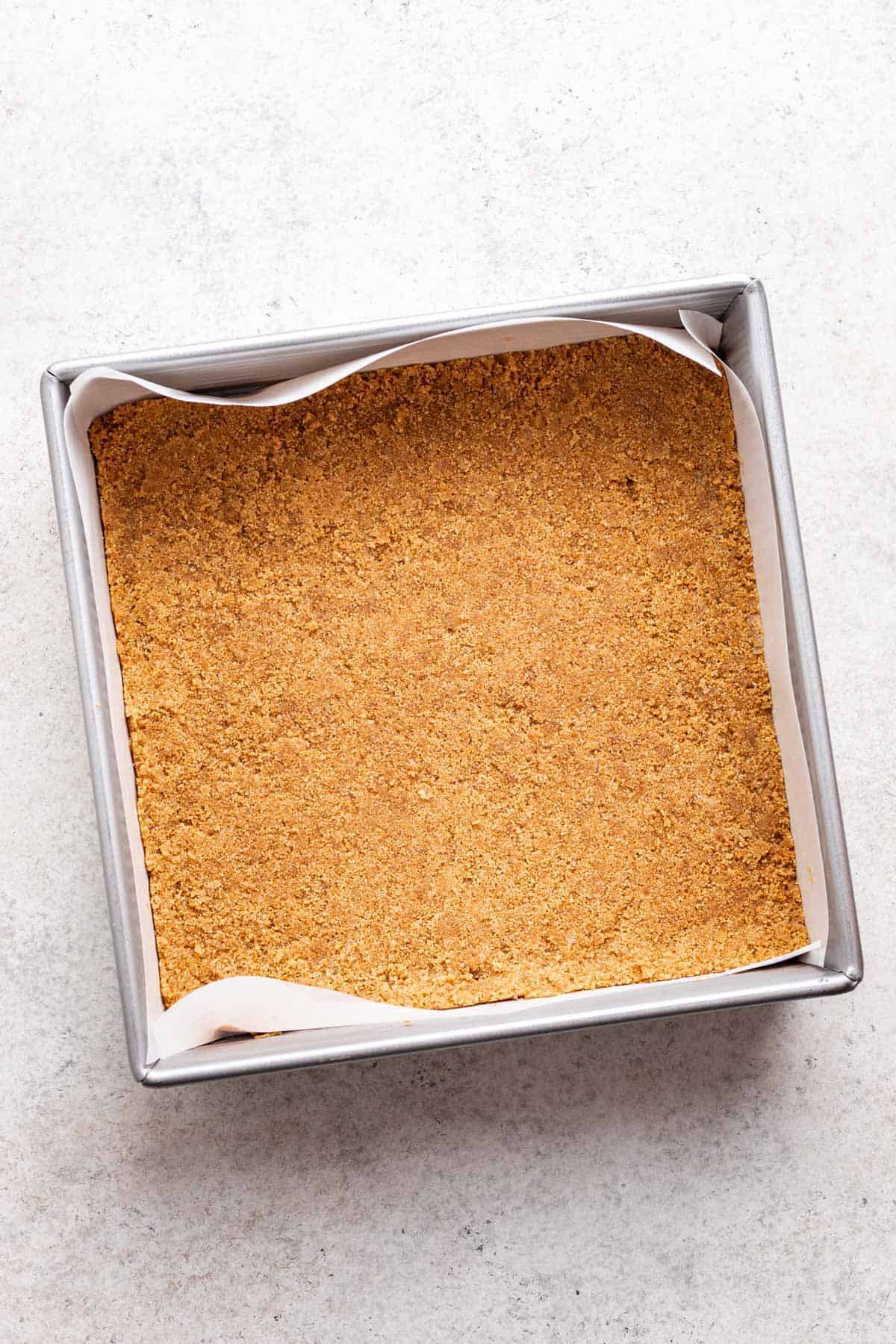 Graham cracker crust pressed into a 9-inch square baking pan.