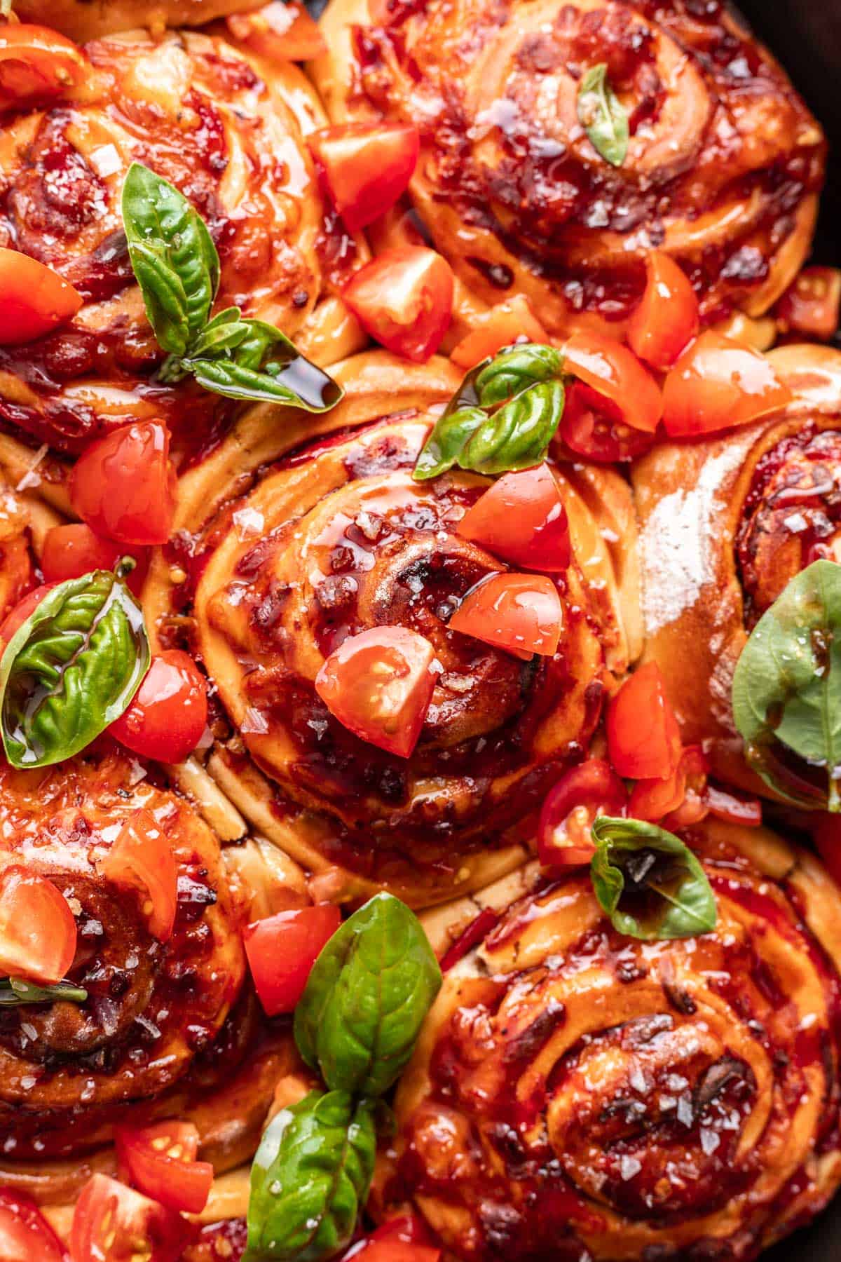 Caprese rolls topped with fresh basil, tomatoes, and balsamic glaze.