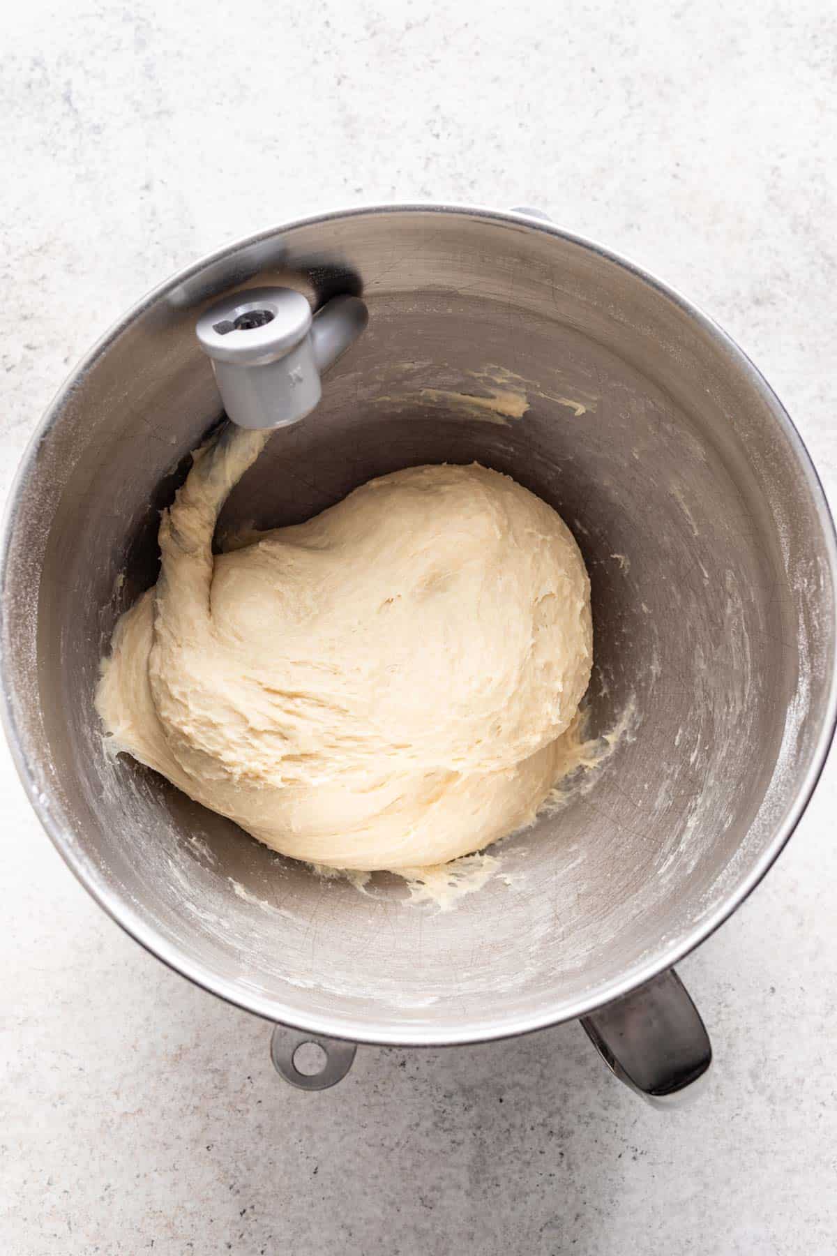 Dough in a large bowl with a dough hook.