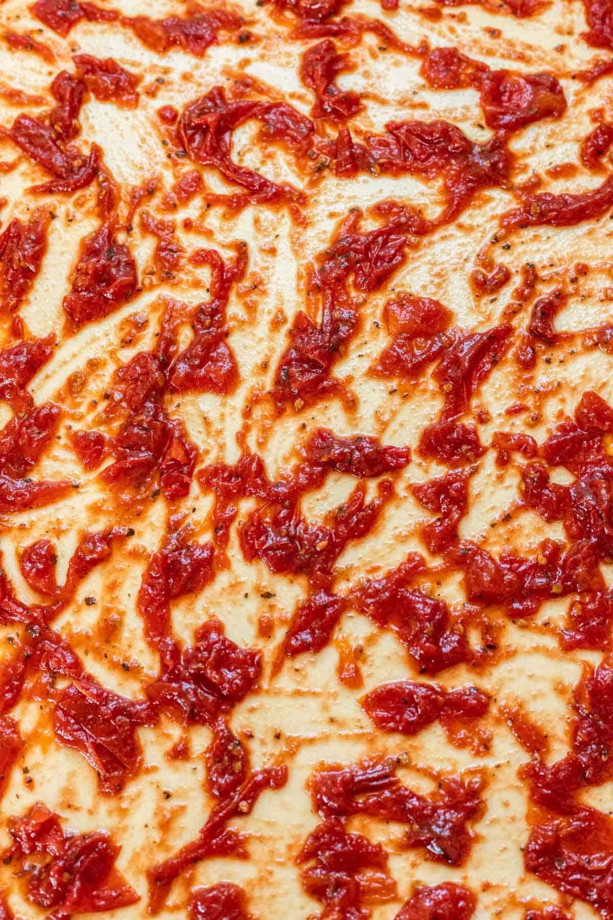 Tomato jam spread over the dough.