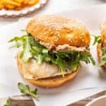 Marry Me Chicken Burger topped with arugula and cheese on a sesame seed bun.
