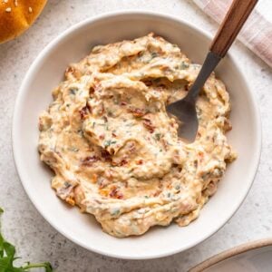 Sun dried tomato aioli in a bowl with a serving spoon.