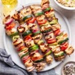 Yogurt marinated chicken skewers on a serving plate.