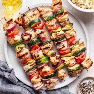 Yogurt marinated chicken skewers on a serving plate.