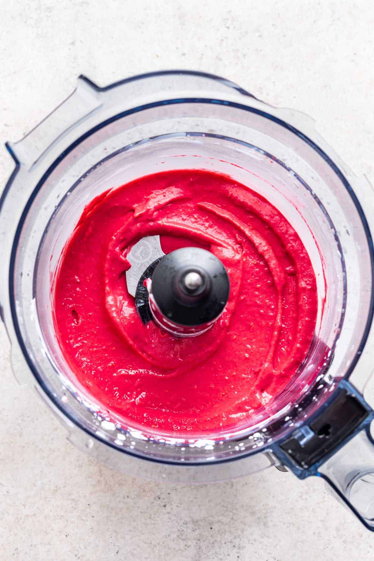 Homemade raspberry sherbet in a food processor.