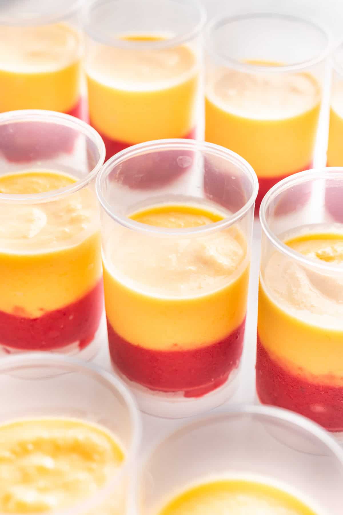 Mango sherbet on top of raspberry sherbet ⅔ of the way up push up popsicle molds.