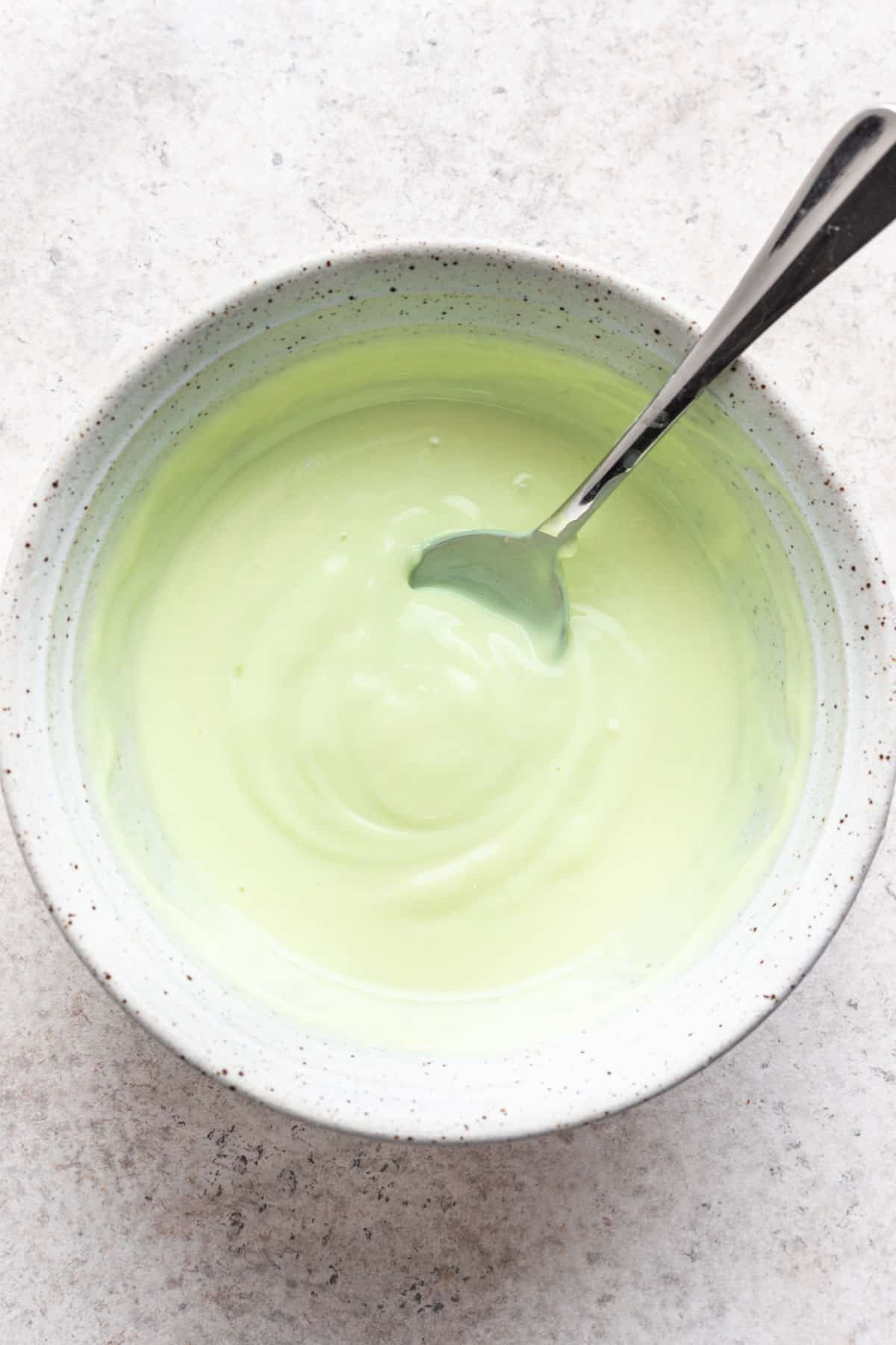 Lime greek yogurt mixed in a bowl with lime juice and agave to make lime sherbet.