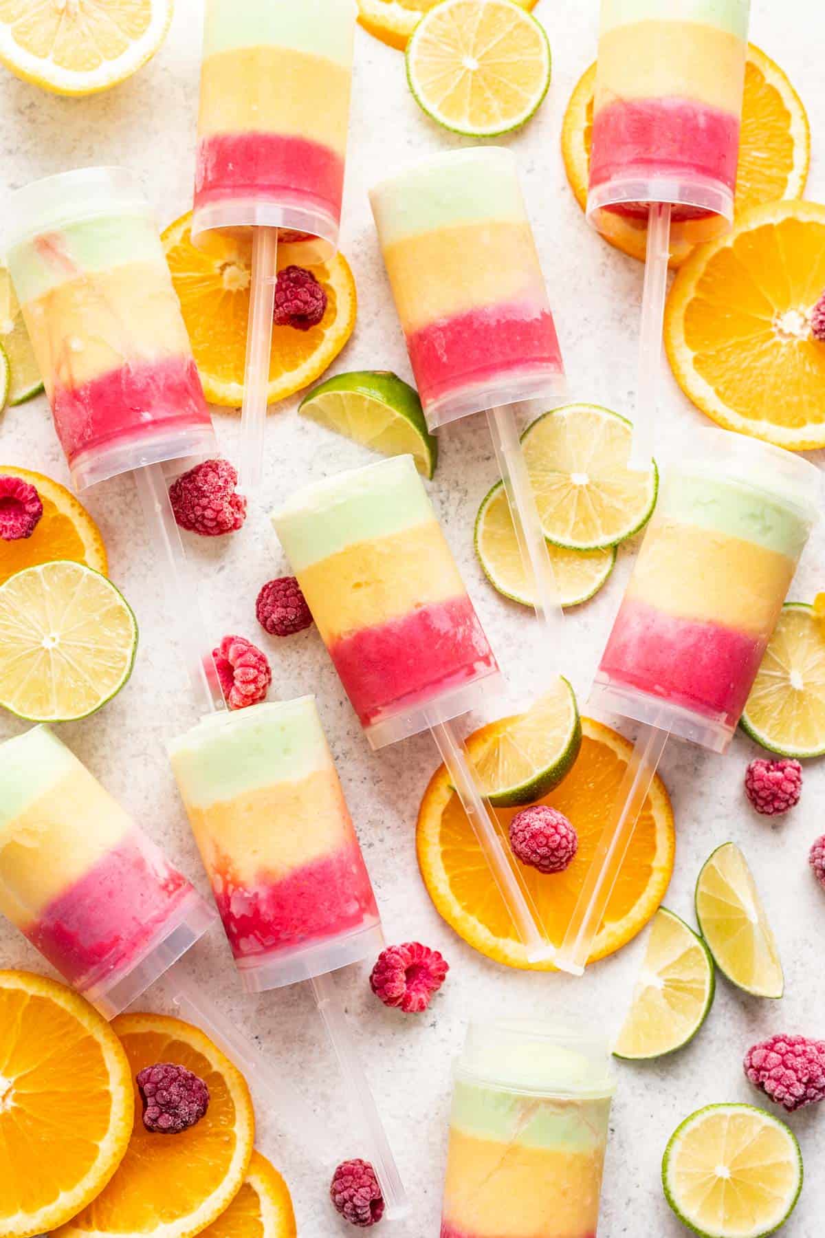 Homemade push up popsicles with fresh citrus fruits around them.